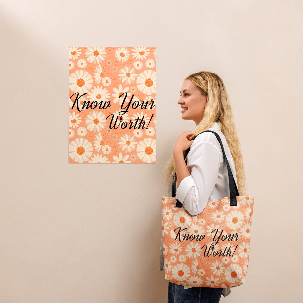 All-over white daisy print tote bag with a pastel pink background “Know Your Worth” text on the front and black denim shoulder straps